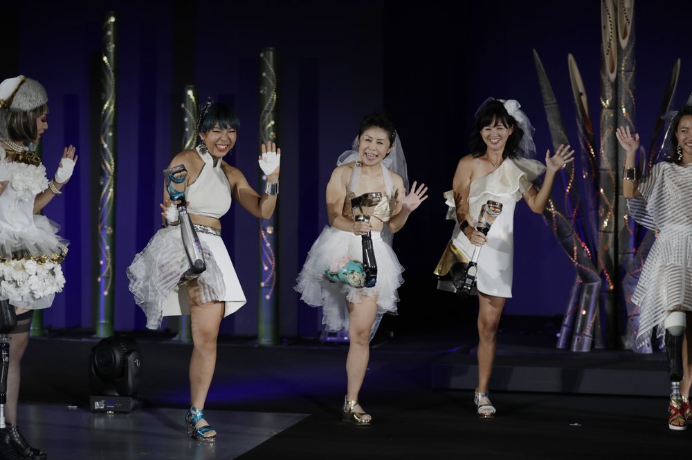 Каэдэ Маэгава, паралимпиец, второй слева, Хитоми Ониси, паралимпиец,и Саяка Мураками, спортсмен, позируют для фотографии