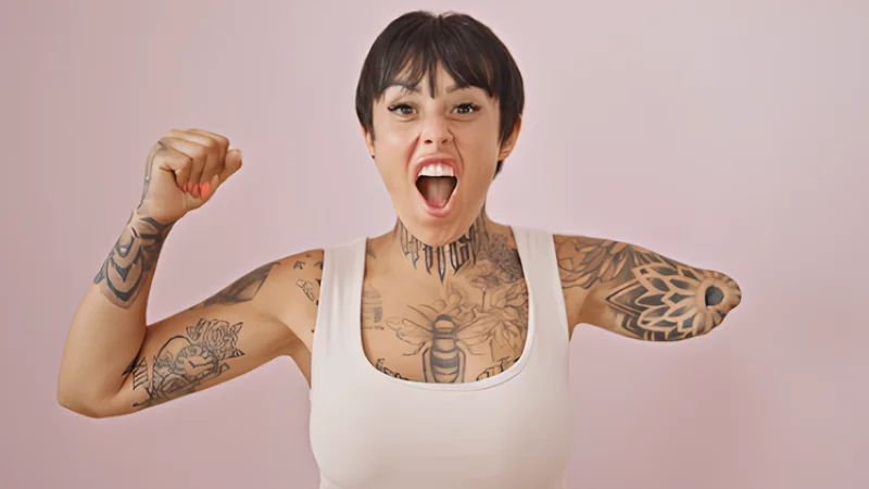 Hispanic woman with amputee arm smiling confident celebrating over isolated pink background