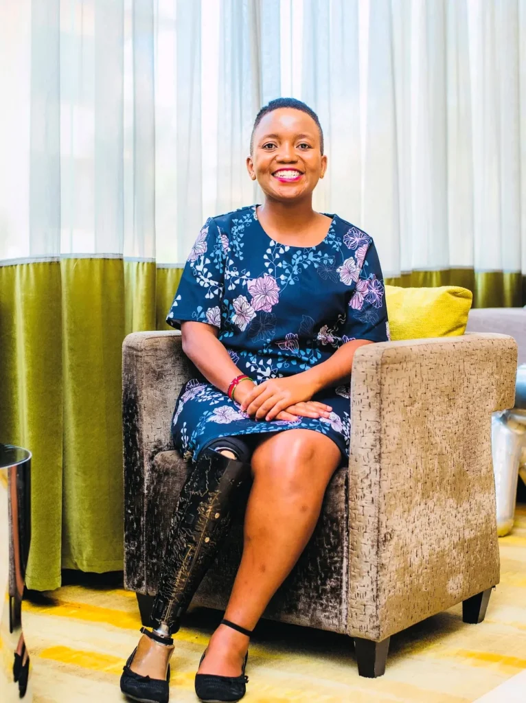 Элизабет Мангени, сидящей на диване и улыбающейся